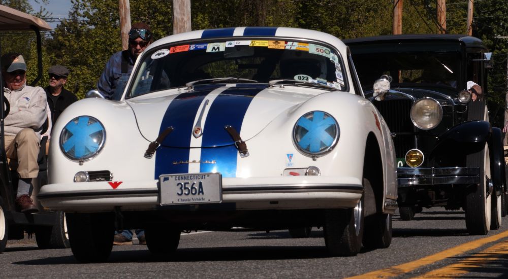 A white 1956 Porsche 356A is shown with blue racing strips.