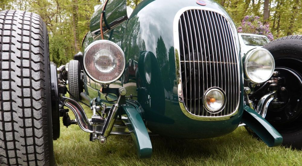 A close up shows the suspension of a green 1958 Fiat Stanguellini.