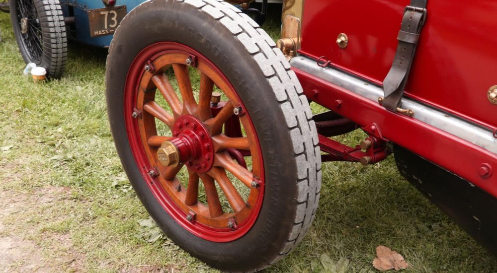 A close up shows the wheel on a red Fiat.