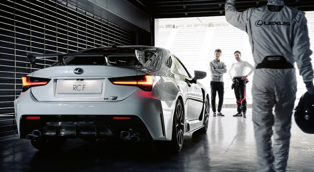 A white 2023 Lexus RC F is shown prked near several people.