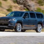 A blue 2024 Jeep Wagoneer is shown driving on a highway.