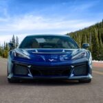 A blue 2025 Chevy Corvette ZR1 is shown rounding a corner.