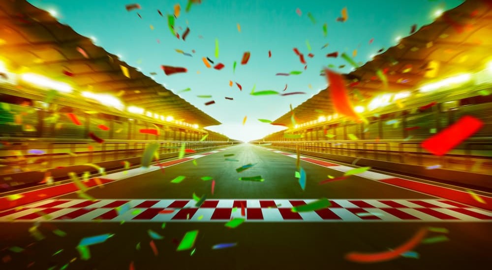 Confetti is shown falling on a racetrack finish line.