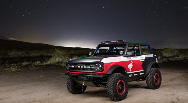 A red and black 2021 Ford Bronco 4600 parked on a track and angled left.