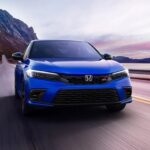 A blue 2024 Honda Civic Si driving from a Honda dealer.
