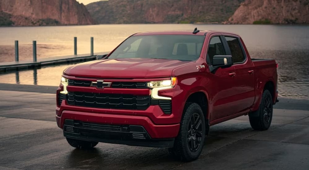 A red 2024 Chevy Silverado 1500 Z71 RST is shown parked near a dock.