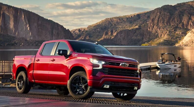 A red 2024 Chevy Silverado 1500 Z71 RST is shown parked near a lake after viewing trucks for sale.