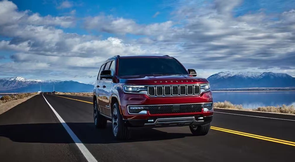 A red 2024 Jeep Wagoneer is shown driving to a Jeep dealer.