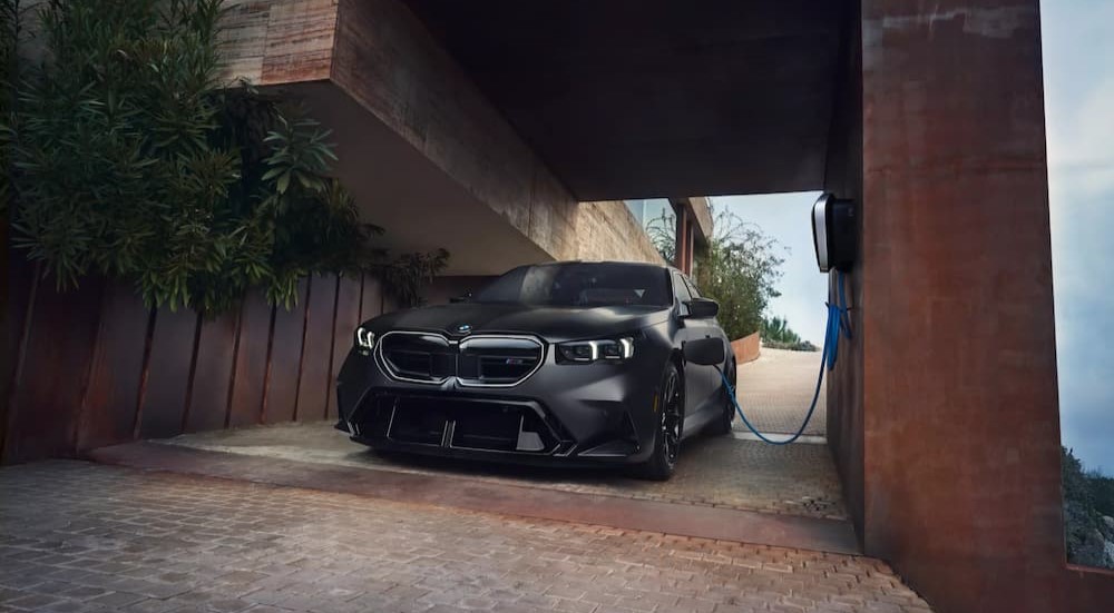 A gray 2025 BMW M5 is shown charging.