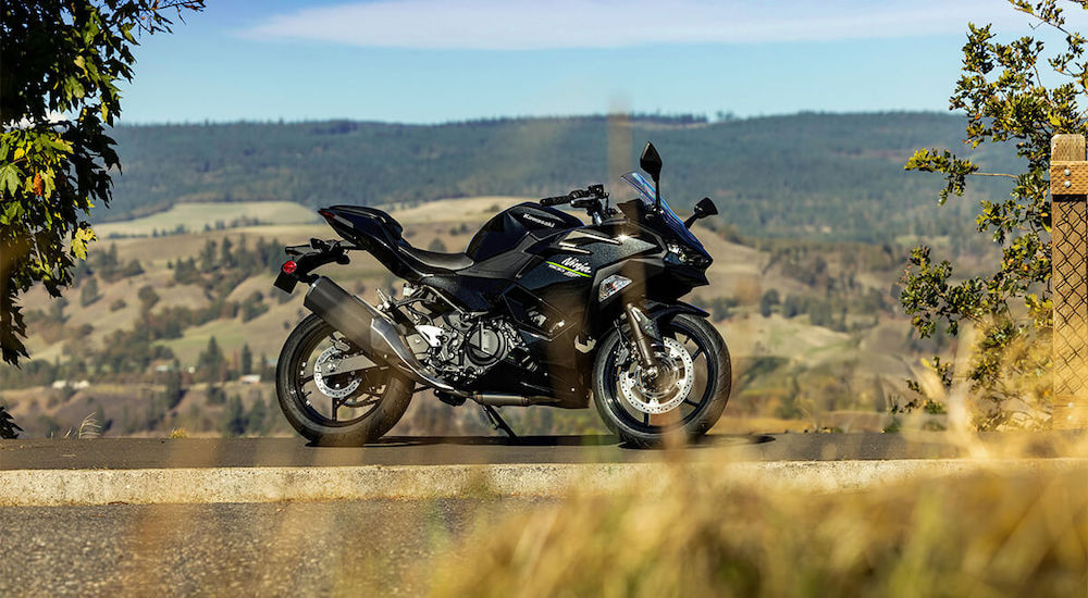 A black 2024 Kawasaki Ninja 500 is shown from the side while parked.