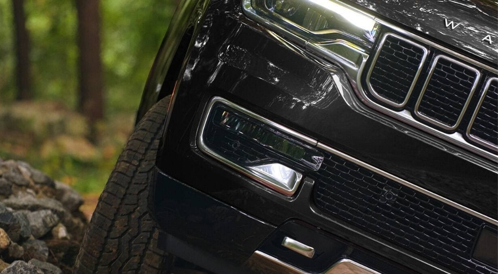 A close up shows a grey 2024 Jeep Wagoneer off-road.