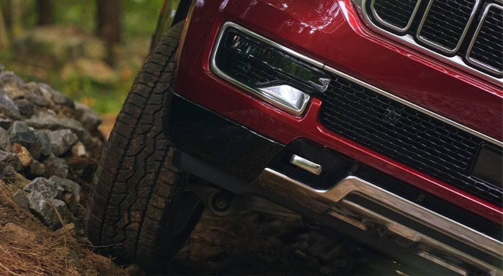 A close-up shows a red 2023 Jeep Wagoneer off-road.