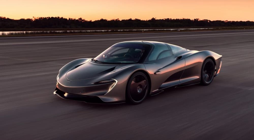 A silver McLaren Speedtail is shown driving on a track.