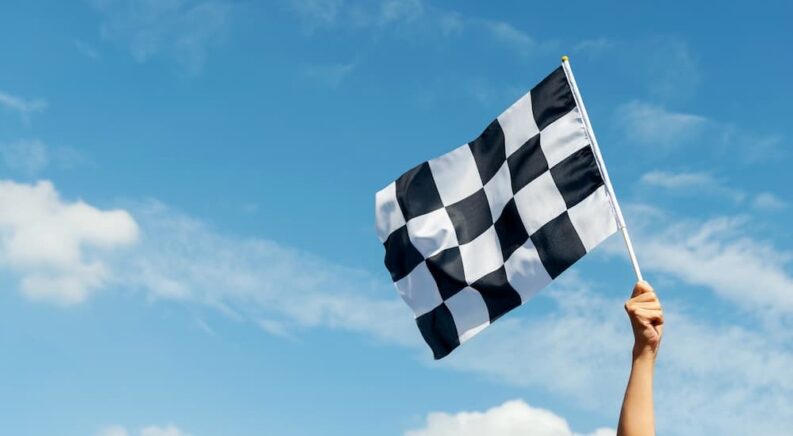 A person holding a checkered flag is shown