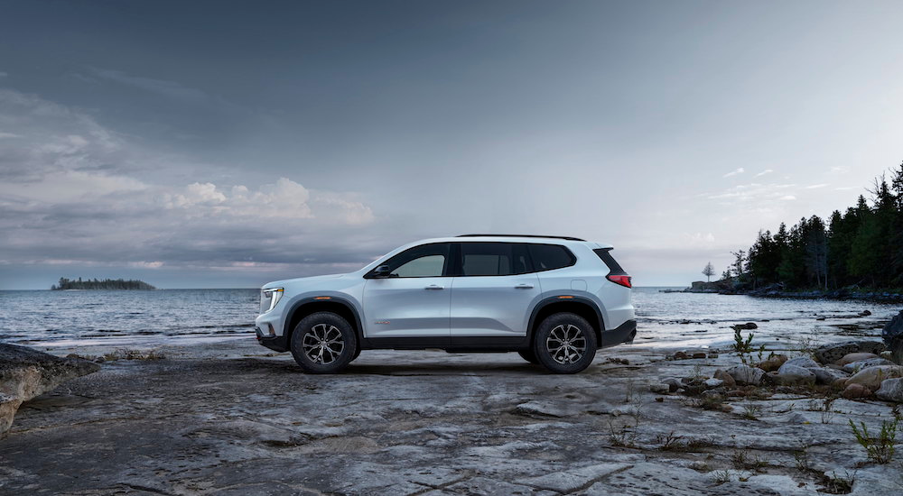 A white 2024 GMC Acadia for sale is shown from the side.