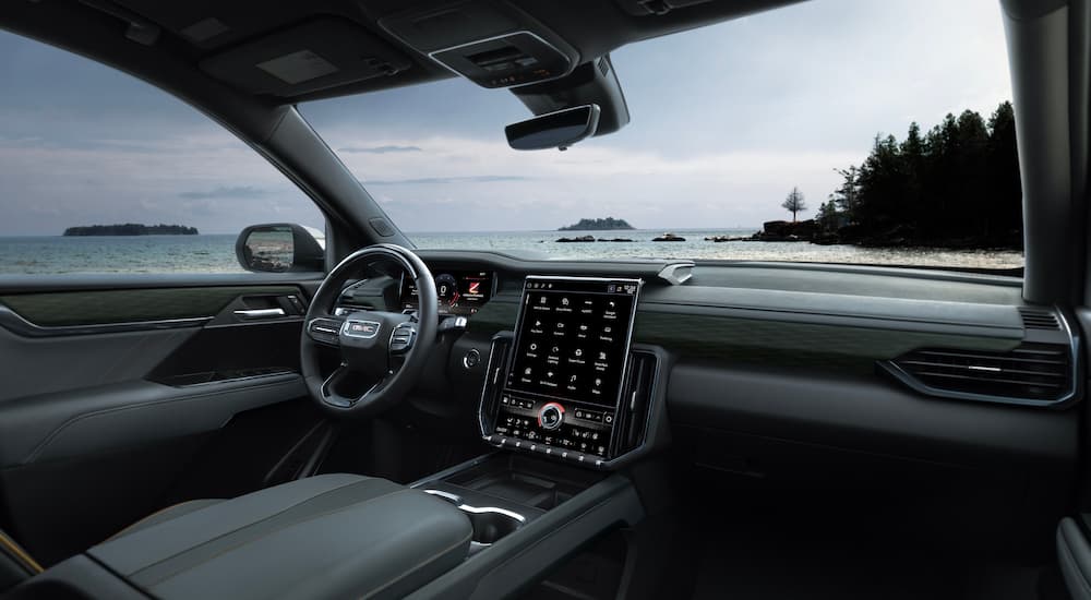 The black interior of a 2024 GMC Acadia AT4 is shown from the passenger seat.