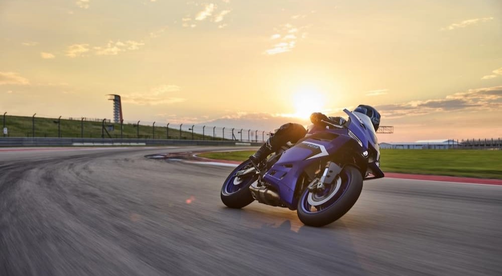 A blue 2025 Yamaha R9 is shown cornering on a track.