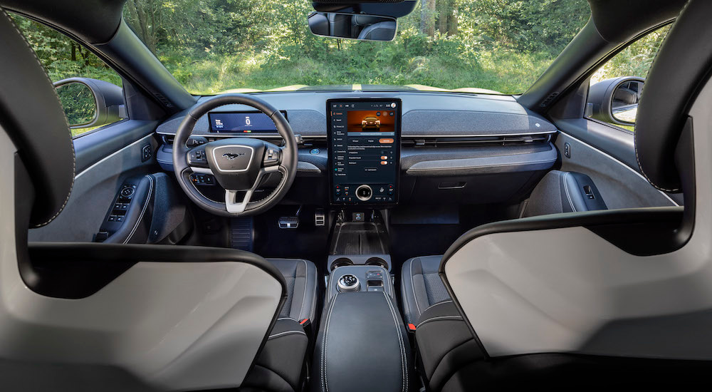 The interior of a 2024 Ford Mustang Mach-E for sale is shown from the rear seats.