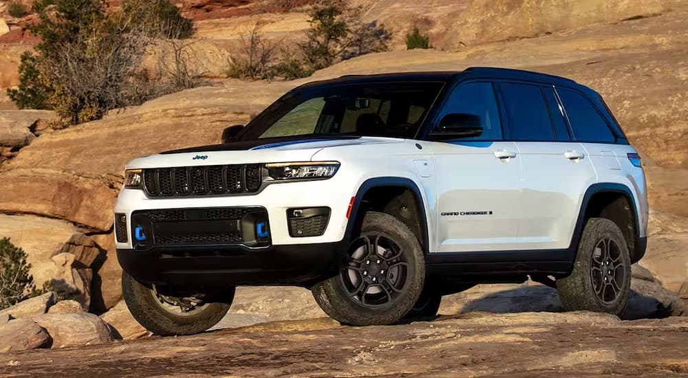 A white 2023 Jeep Grand Cherokee is shown from the front at an angle.