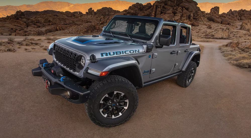 A grey 2023 Jeep Wrangler Rubicon, a used Jeep for sale, parked off-road in a desert and angled left.