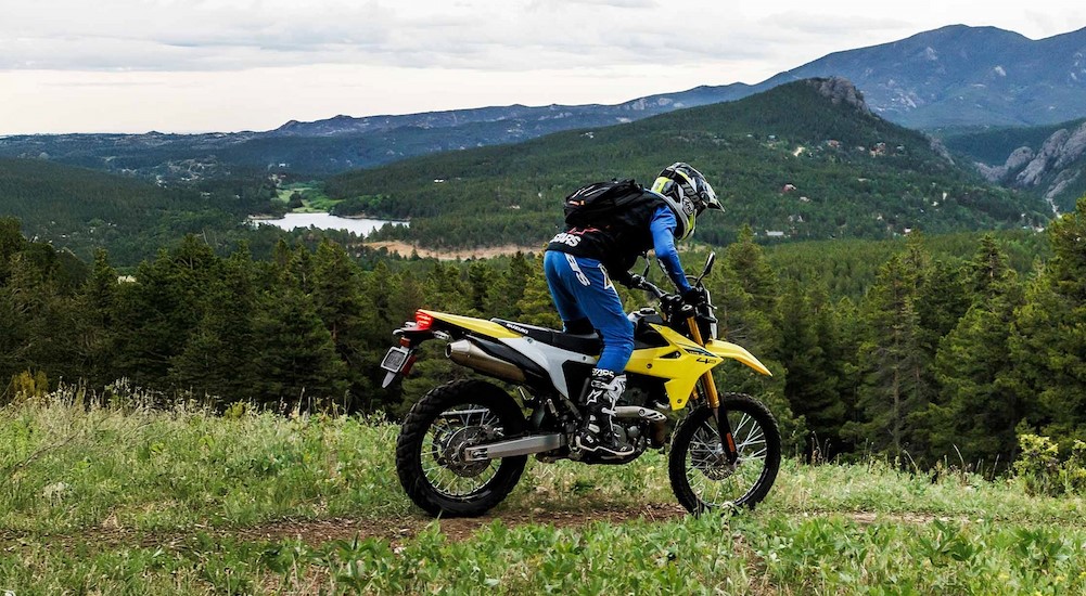 A yellow 2025 Suzuki DR-Z42 is shown riding off-road.