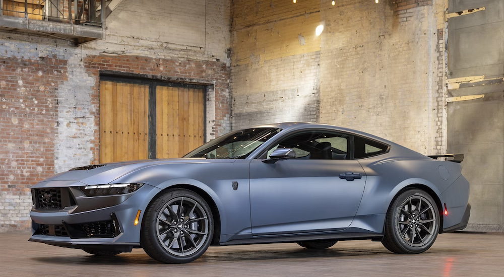 A silver 2024 Ford Mustang Dark Horse parked in a brick warehouse.