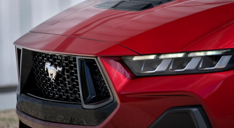 The front end of a red 2024 Ford Mustang at a Ford dealer.