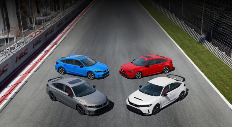 High angle view of four multicolored 2025 Honda Civics parked on a race track.