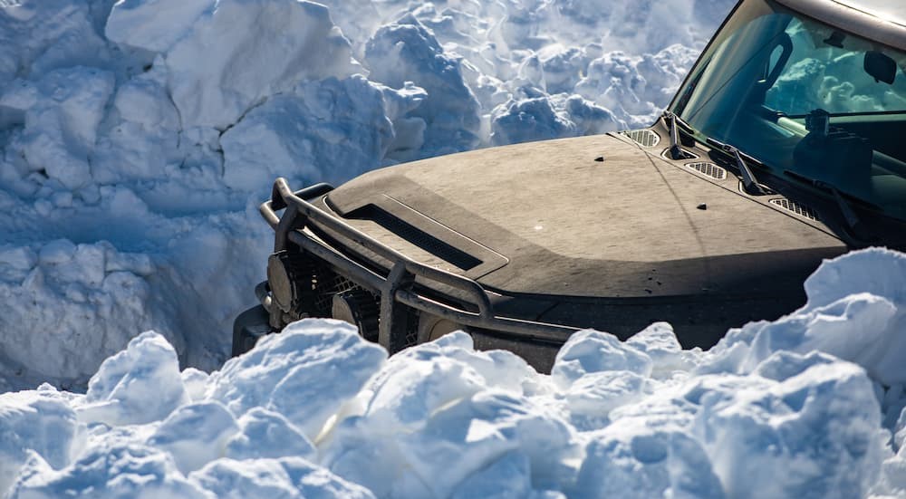 A vehicle is shown driving through snow.