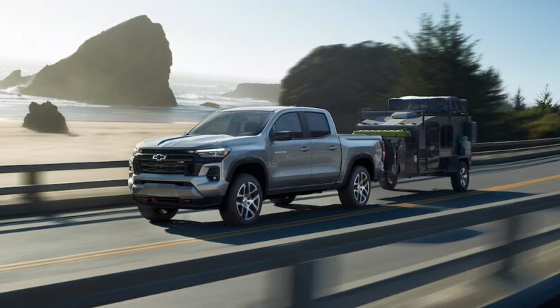 A silver 2024 Chevy Colorado Z71 is shown driving near an ocean.