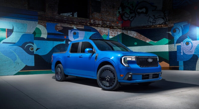 A blue 2025 Ford Maverick Lobo parked in front of modern street art.