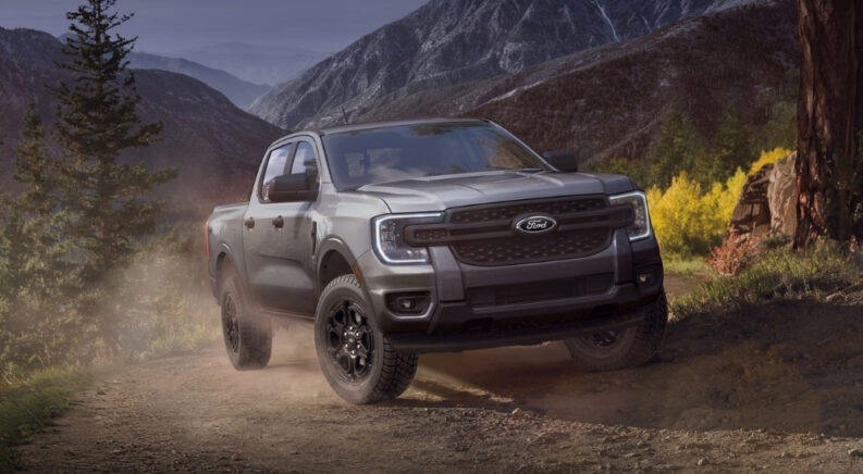 A grey 2025 Ford Ranger Raptor driving on a mountain trail.