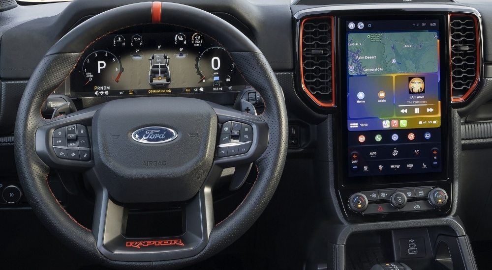 Close-up of the steering wheel and infotainment screen in a 2025 Ford Ranger Raptor at a Ford dealer.