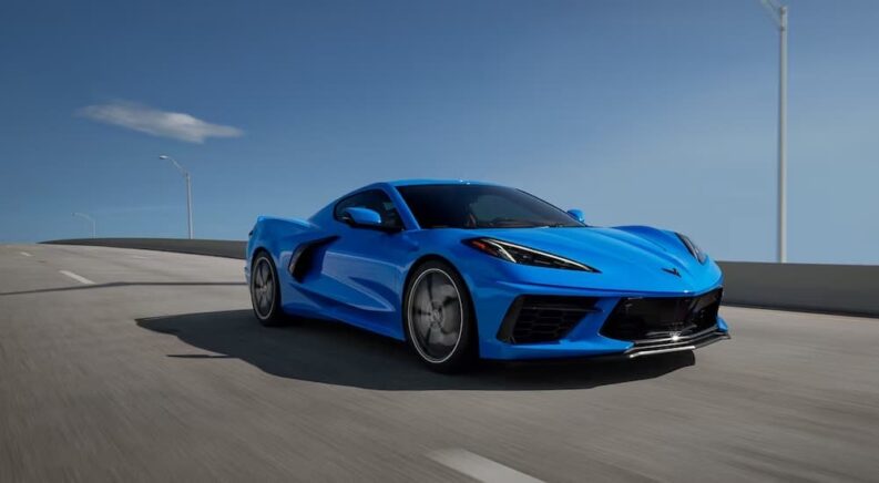 A blue 2025 Chevy Corvette Stingray is shown driving to a "Chevy dealer near me."