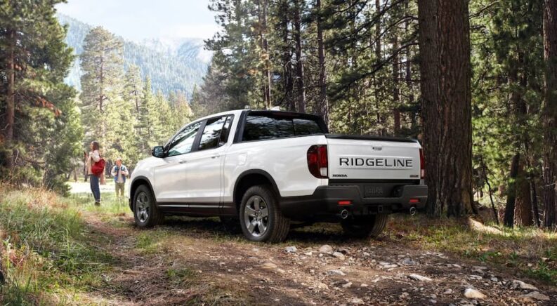 A white 2024 Honda Ridgeline TrailSport is shown parked off-road.