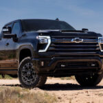 A black 2024 Chevy Silverado 2500 HD High Country parked off-road and angled right.