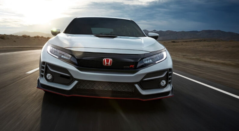 A white 2021 Honda Civic Type-R is shown driving to a Honda dealer.