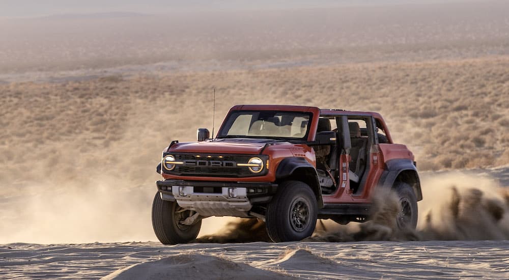 A red 2025 Ford Bronco Raptor is shown from the front at an angle.