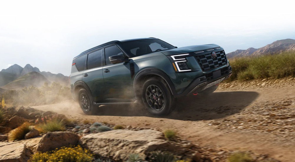 A green 2025 Nissan Armada Pro-4X is shown driving on a dirt road.