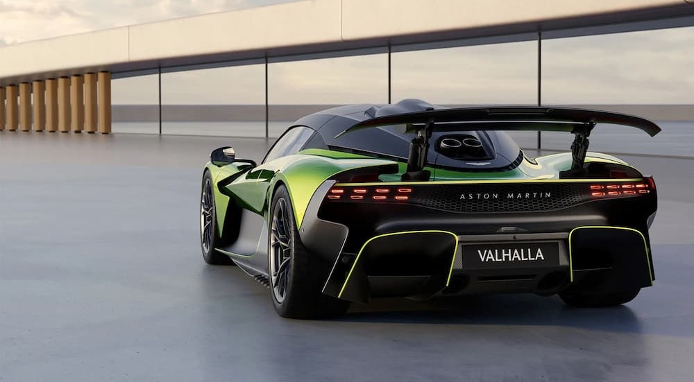 A green Aston Martin Valhalla is shown parked on a sunny day.