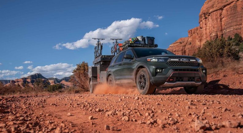 A dark green 2024 Ford Explorer Timberline off-roading through a desert.