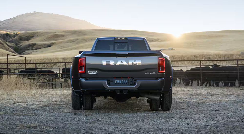 Rear view of a grey 2025 Ram 3500 Limited Longhorn parked on a farm.