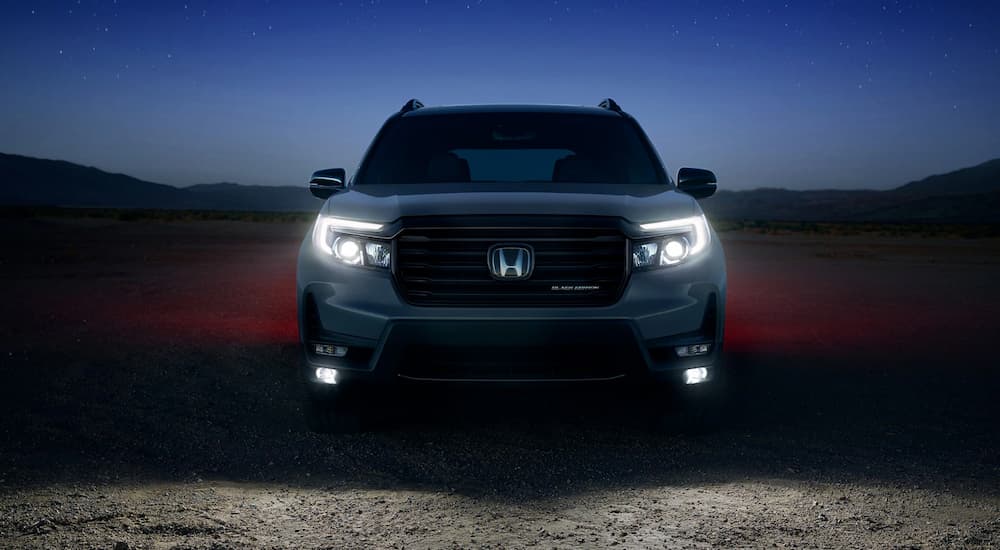 Front angle view of a grey 2025 Honda Passport TrailSport parked off-road.