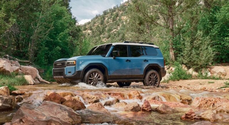 A blue 2025 Toyota Land Cruiser for sale is shown driving off-road.