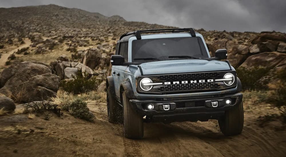 A light blue 2021 Ford Bronco driving on a trail.