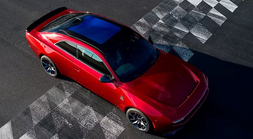 A red 2025 Dodge Charger Daytona parked on a finish line.