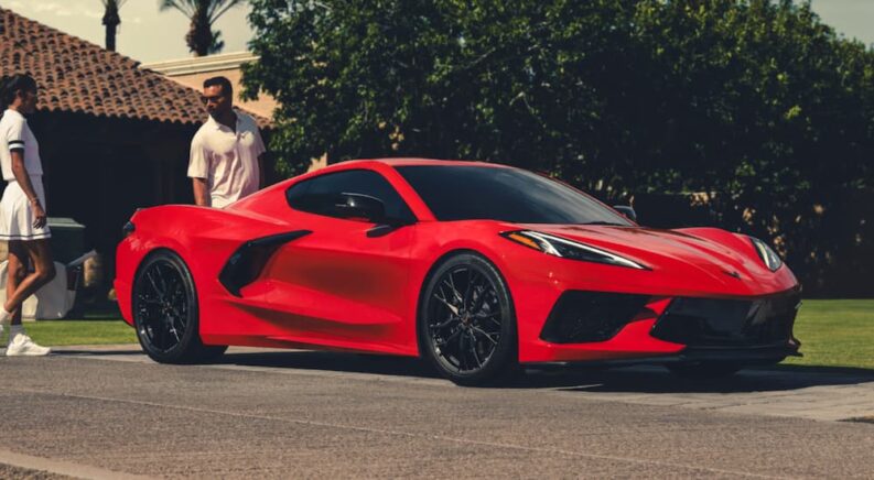 A red 2025 Chevy Corvette Stingray parked on a driveway after visiting a Chevy dealer.