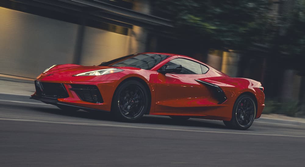 A red 2025 Chevy Corvette Stingray driving down a road.