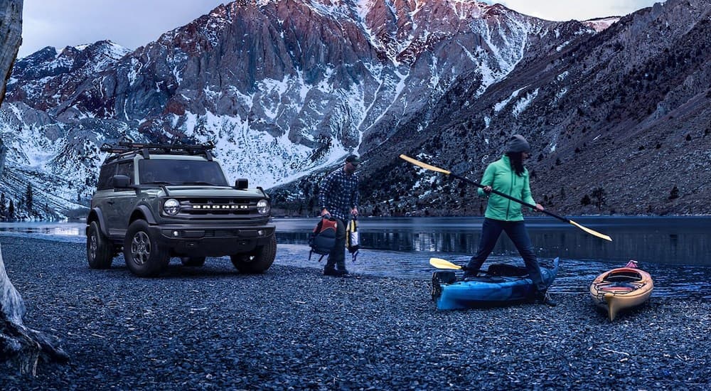 A grey 2024 Ford Bronco Big Bend parked by a lake.