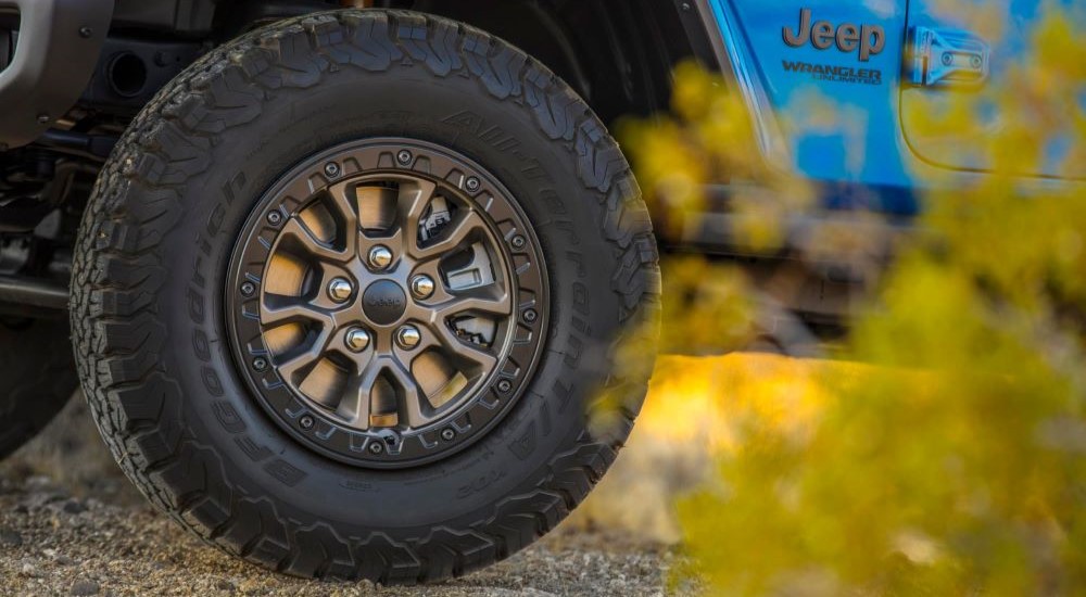 Close-up of the front wheel of a blue 2024 Jeep Wrangler Rubicon for sale